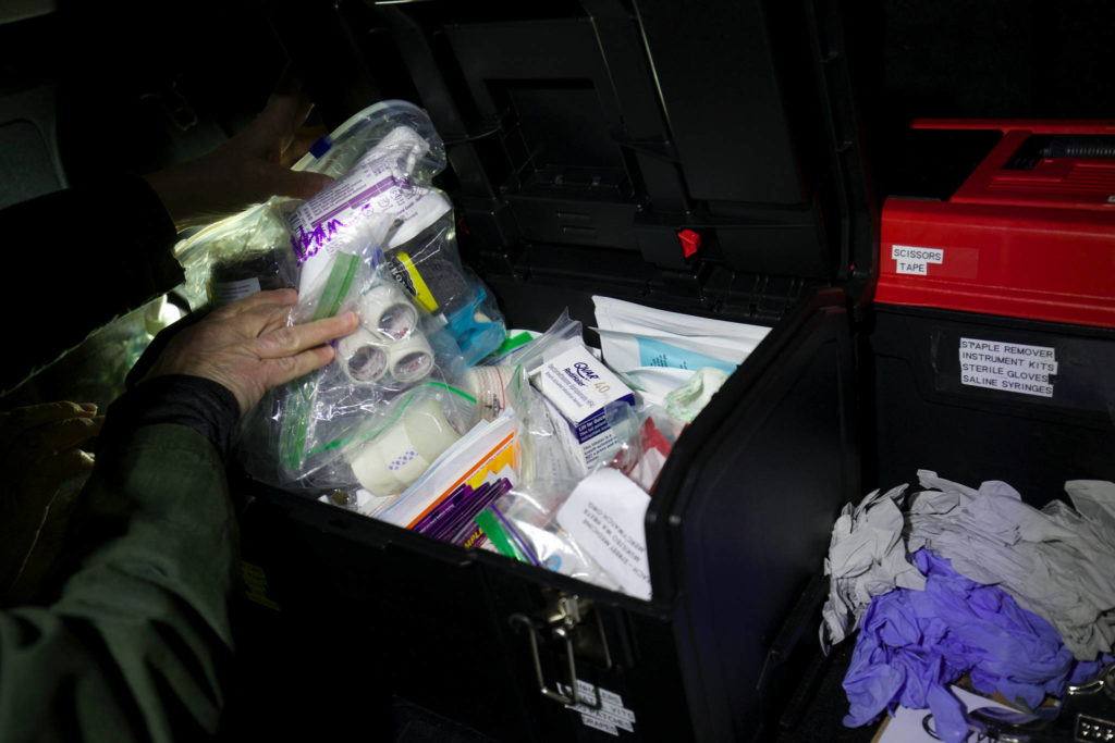 Sheila Murphy digs through a toolbox filled with medical supplies in search of antibiotics. (Andy Bronson / The Herald)
