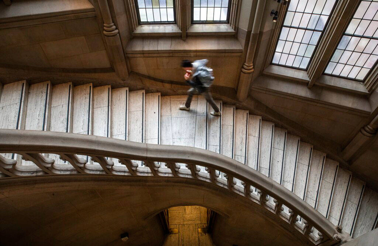 A student climbs a stairway at the University of Washington’s Suzzallo library on March 6, after in-person classes were cancelled due to coronavirus concerns. (Steve Ringman / The Seattle Times)