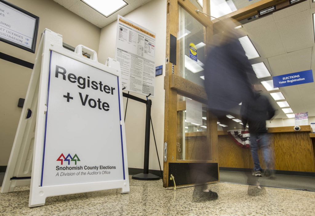 People walk in and out of the Snohomish County Auditor’s Office to drop off ballots and register to vote on Tuesday in Everett. (Olivia Vanni / The Herald)
