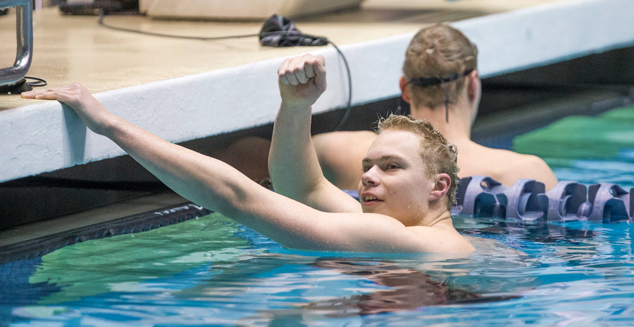 Kamiak’s Vlad Gilszmer raises a fist after he and his brother Slava finished first and second in the 500 freestyle at the Class 4A state championships in February. (Andy Bronson / The Herald)