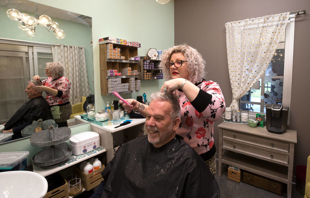 HoneyComb Salon owner Julia Barbee gives Don Zimmerman a haircut in her studio inside Sola Salon Studios on Friday in Mill Creek. On Monday, the state ordered all salons be closed for two weeks. (Andy Bronson / The Herald)
