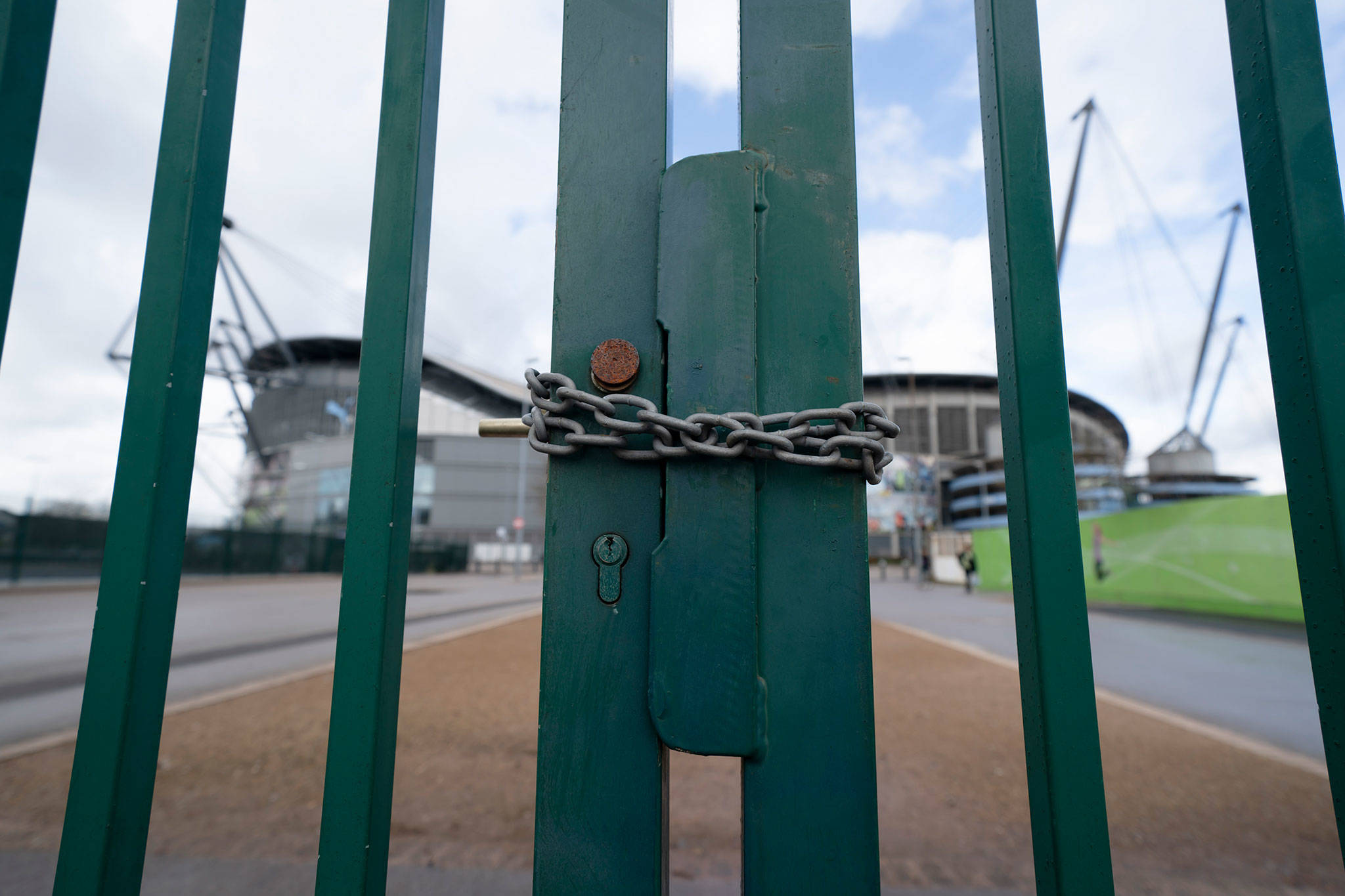 A locked gate is seen by the Etihad Stadium where Manchester City was due to play Burnley in an English Premier League soccer match Saturday. All English soccer games were cancelled due to the spread of the COVID-19 Coronavirus. (AP Photo/Jon Super)