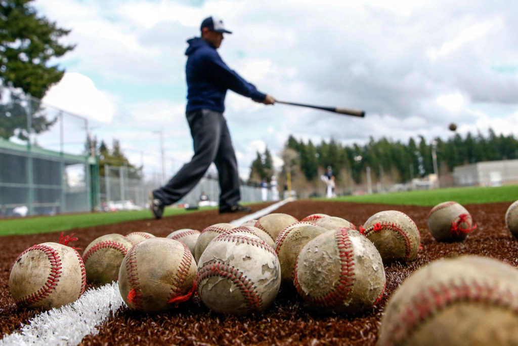 Meadowdale assistant coach Allen Paves hits to infielders during practice Thursday afternoon at Meadowdale High School in Lynnwood. (Kevin Clark / The Herald)
