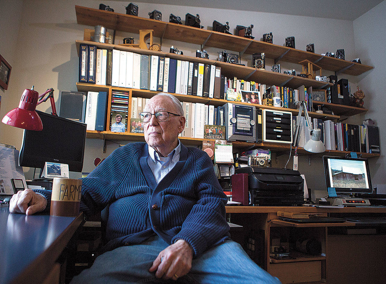 Cameras and binders of film slides surround Gerald Magelssen in his office at his Arlington home. (Olivia Vanni / The Herald)