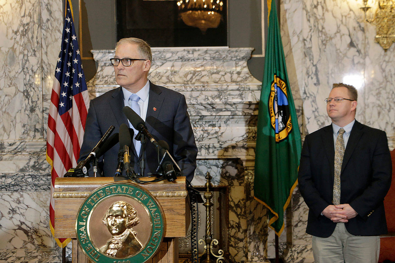 Washington Gov. Jay Inslee (left) is joined by Superintendent of Public Instruction Chris Reykdal on Friday as he discusses the expansion of school closures and prohibition of large gatherings across all of Washington in an effort to slow the spread of the new coronavirus. (AP Photo/Rachel La Corte)