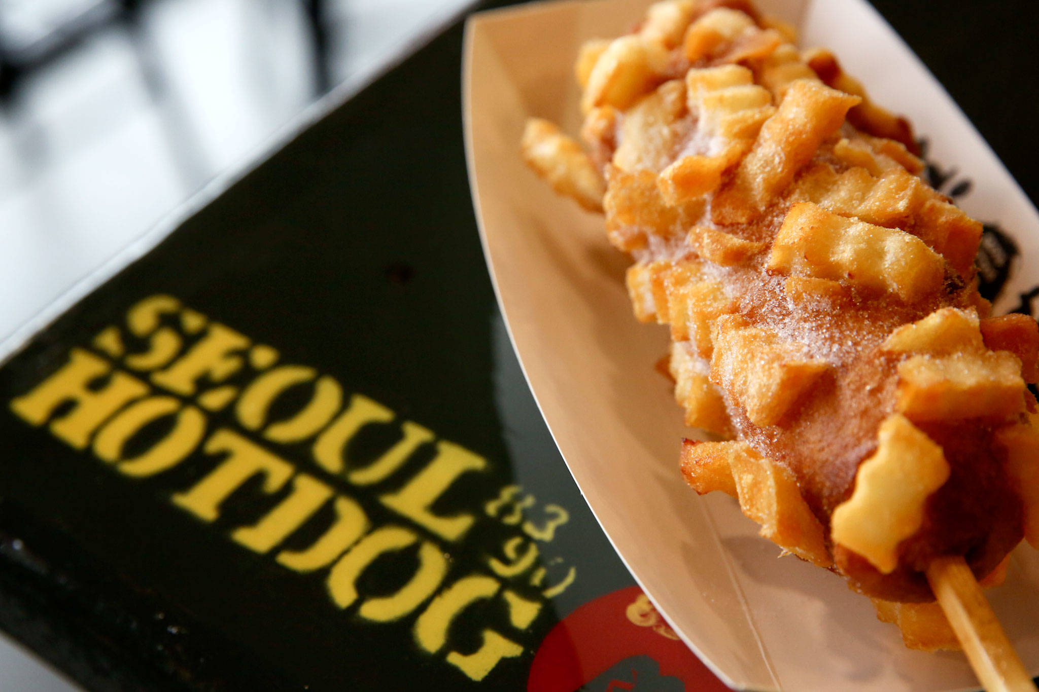 A deep-fried hot dog on a stick studded with french fries at Seoul Hotdog in Lynnwood. (Kevin Clark / Herald file)