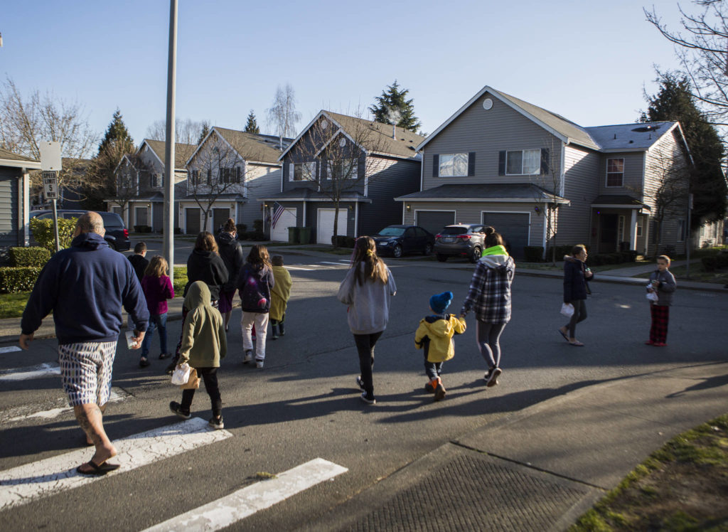 Families and children walk back to their homes after receiving their meals on Wednesday in Marysville. (Olivia Vanni / The Herald)
