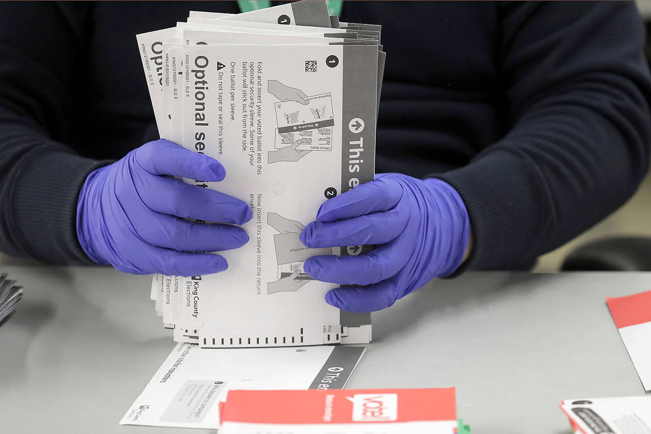 A worker wears gloves while handling ballots from the Washington state primary election March 10 at the King County Elections headquarters in Renton. (AP Photo/Ted S. Warren)