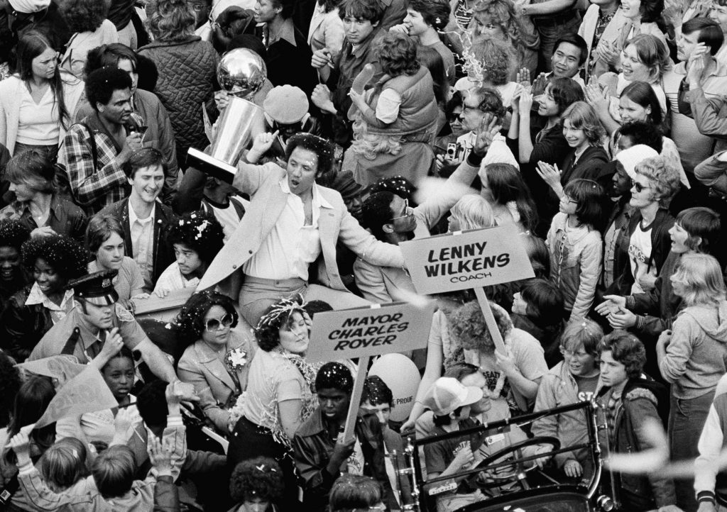 Supersonics Coach Lenny Wilkens holds up the NBA championship trophy before some of the thousands of fans that lined Seattle streets in 1979 in celebration of the Sonics victory over the Bullets. (AP Photo)
