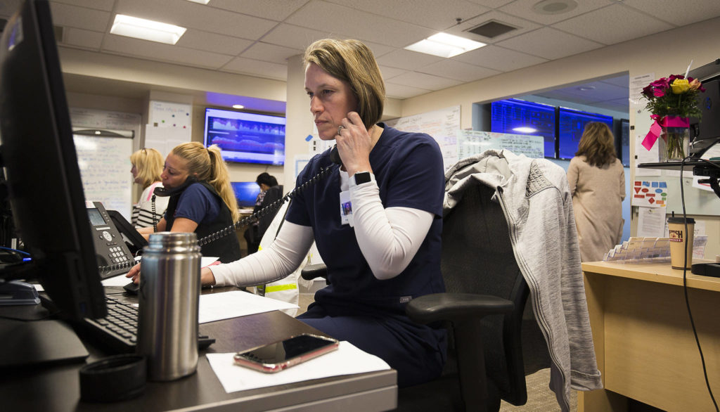 Registered Nurse Andrea Rairdin takes and makes call at the Command Center in Providence Regional Medical Center on Friday, March 20, 2020 in Everett, Wa.(Andy Bronson / The Herald)
