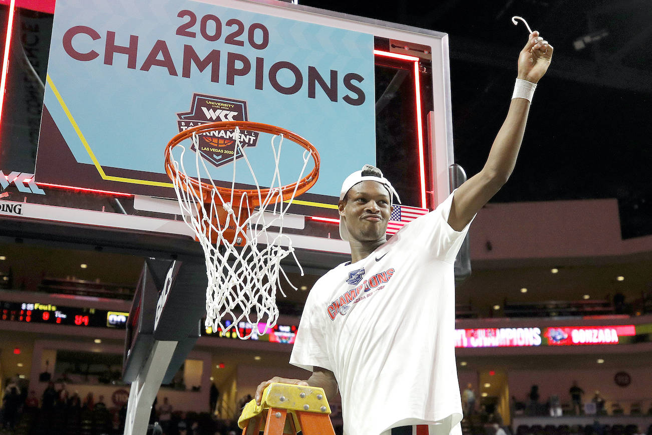 Gonzaga’s Joel Ayayi (11) celebrates as he cuts a piece of the net after defeating Saint Mary’s in the final of the West Coast Conference men’s basketball tournament on March 10 in Las Vegas. (AP Photo/John Locher)
