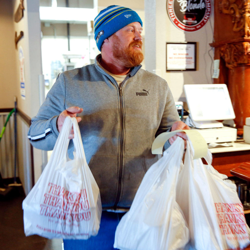 David Smithburg carries a customer’s to-go order at The Amarillo in Monroe on March 20. (Kevin Clark / The Herald)
