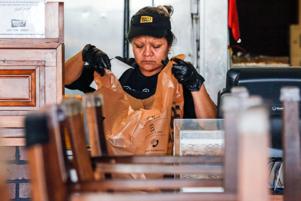 Vivian Martinez prepares an order for the drive-thru at Dickey’s Barbecue Pit in Everett on March 20. (Kevin Clark / The Herald)
