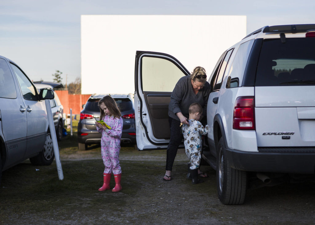 Kambrielle Barth, 4, tries to open her Sour Patch Kids as her grandmother helps her little brother, CJ Barth, 3, into the car. (Olivia Vanni / The Herald)
