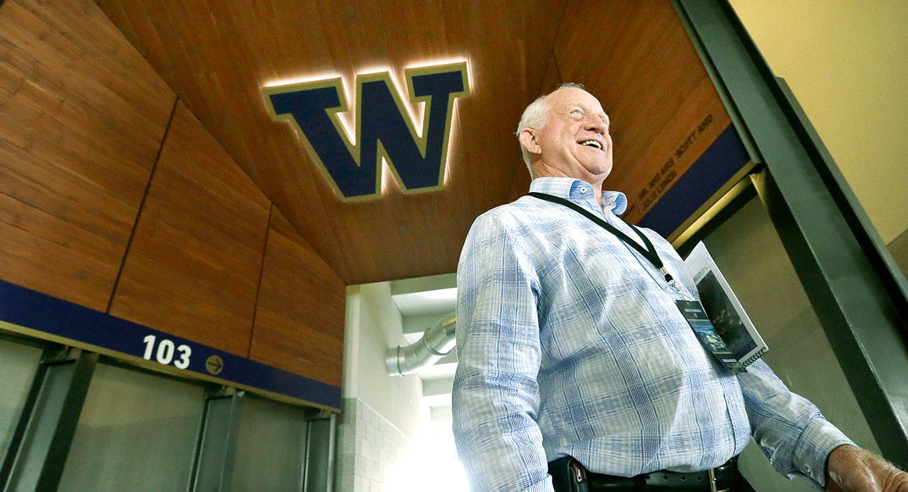 Former head coach Jim Lambright smiles as he stands at a concourse entrance in the newly renovated Husky Stadium in Seattle on Aug. 28, 2013. Lambright has died at age 77, the school announced Sunday. Lambright spent nearly four decades associated with the Washington program as a player, assistant coach and head coach. (AP Photo/Elaine Thompson, file)