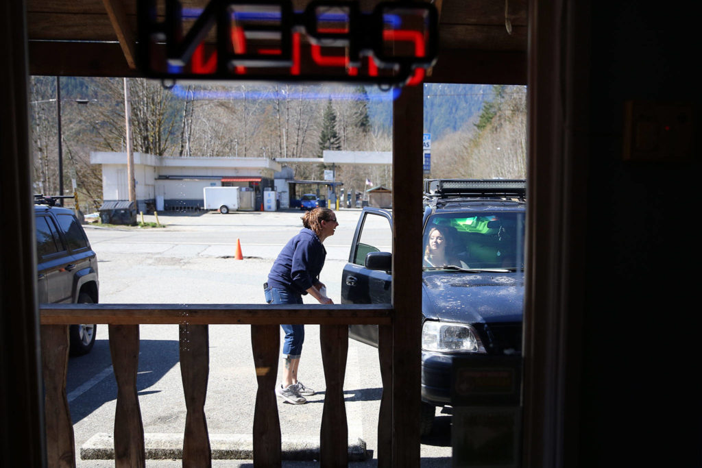 Dee Hatch delivers a food order to a waiting customer at Sky Deli in Skykomish, the last town on U.S. 2 before Stevens Pass. (Kevin Clark / The Herald)
