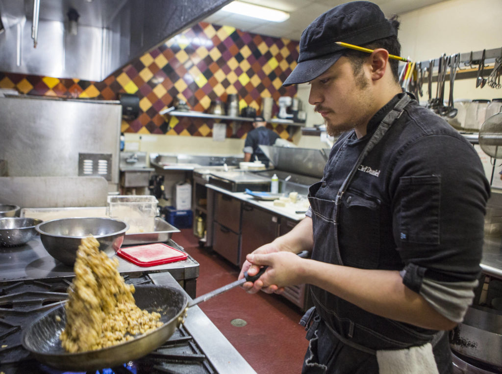 Senior sous-chef Daniel Demidoff preps walnuts in the kitchen on Jan. 30 in Everett. (Olivia Vanni / The Herald)
