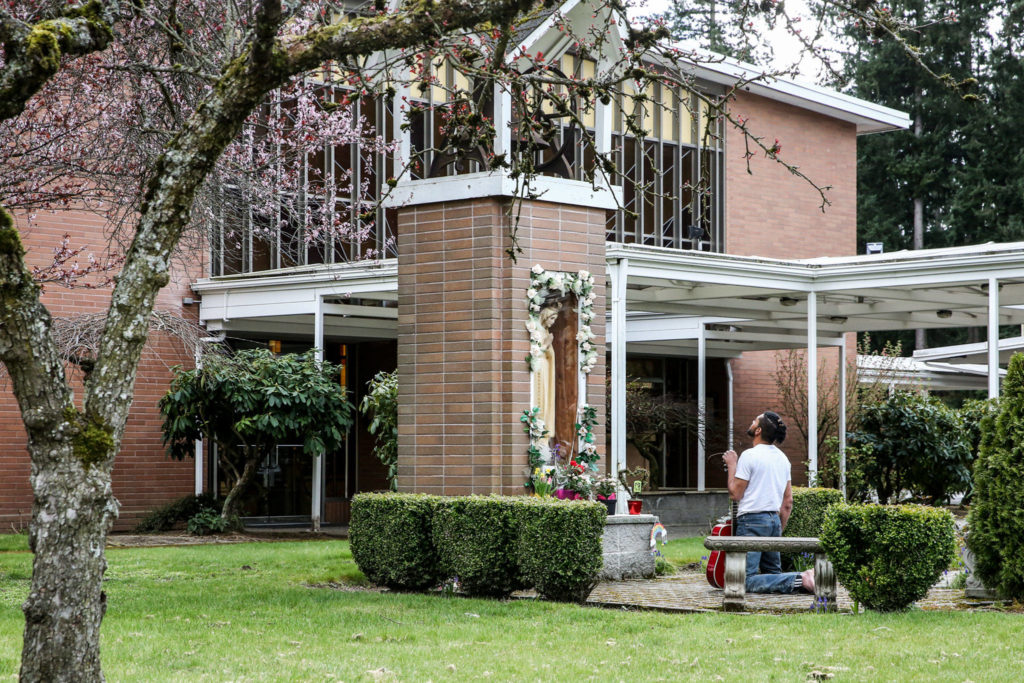 Amidst the COVID-19 quarantine and the closure of St. Mary’s Catholic Church, a worshiper prays in Marysville on March 24. (Kevin Clark / The Herald)