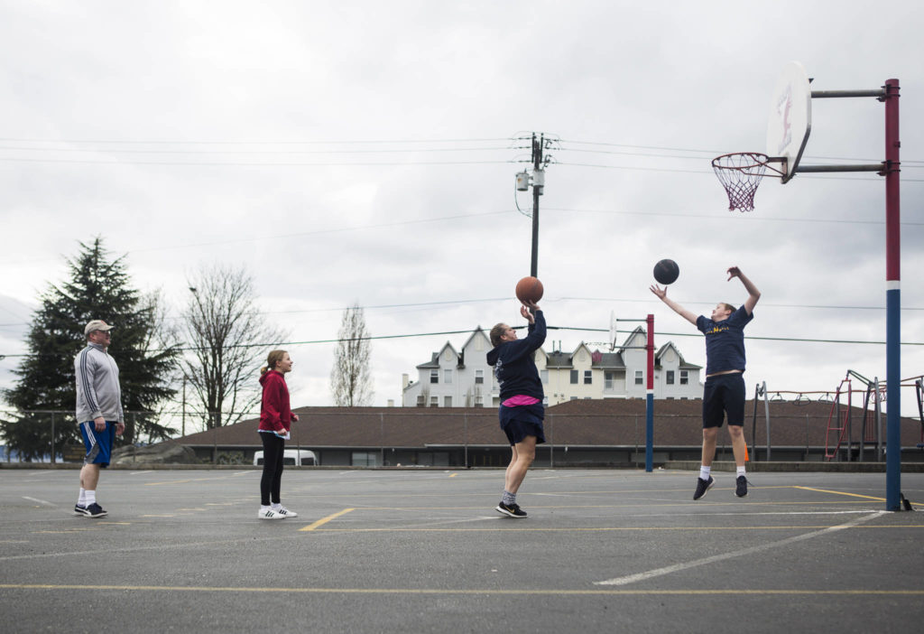 The Cook family plays bump during their “daily P.E class” that they do as a family to get out of the house on March 28 in Everett. (Olivia Vanni / The Herald)