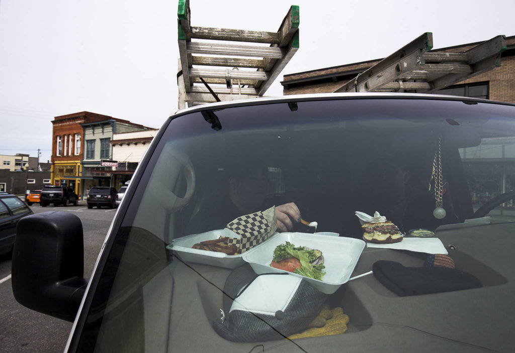 With a takeout meal on the dashboard, Rebecca and Randy Theall enjoy a date lunch away from the kids along First Street on March 17 in Snohomish. (Andy Bronson / The Herald)
