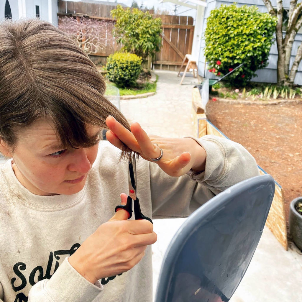 Emily Leopold trims her bangs, an increasingly common beauty routine with hair salons closed because of the coronavirus pandemic and Gov. Jay Inslee’s emergency orders. (Courtesy of Al Leopold)
