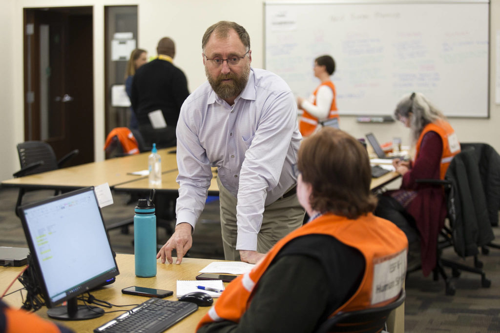 Jason Biermann, Director of the Department of Emergency Management, chats with Jackie Anderson about human services needs on March 30 in Everett. (Andy Bronson / The Herald)
