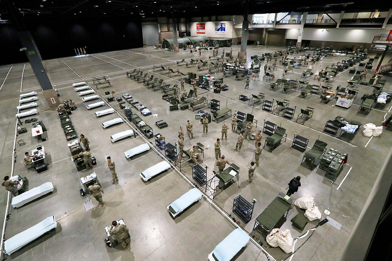 U.S. Army soldiers from Fort Carson, Colorado, and Joint Base Lewis-McChord work to set up a field hospital inside CenturyLink Field Event Center March 31 in Seattle. (AP Photo/Elaine Thompson)