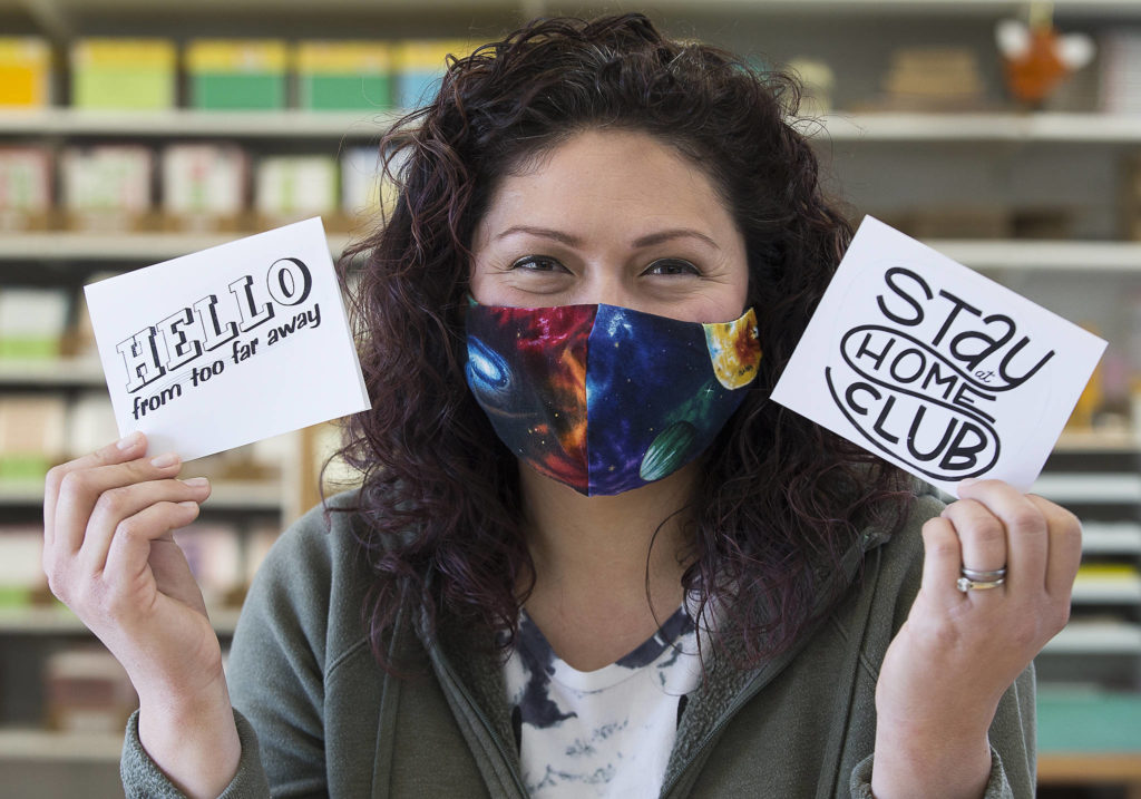 Cat Snapp shows off two of her downloadable cards in her studio in Everett. The cards print in black and white, so the customer can color them in themselves. (Andy Bronson / The Herald)
