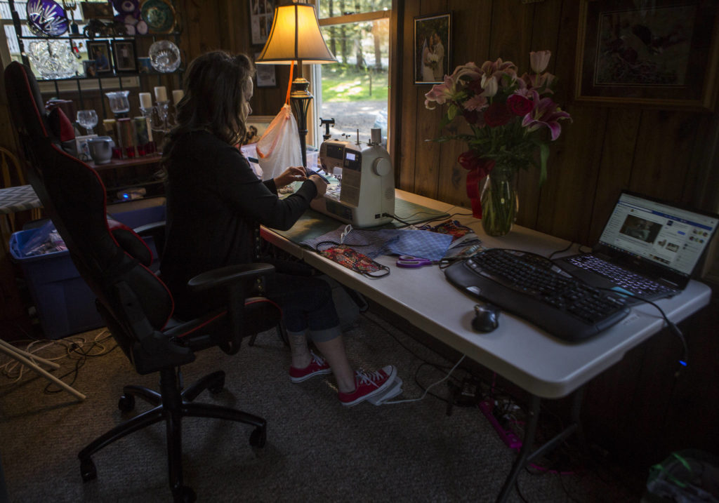 Nikki Speaks works at her new makeshift crafting table in her living room on April 10 in Woodinville. (Olivia Vanni / The Herald)
