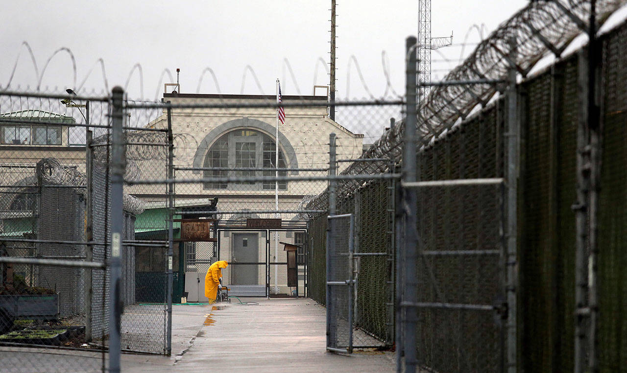 In this file photo taken Jan. 28, 2016, a man does maintenance work between razor wire-topped fences at the Monroe Correctional Complex. (AP Photo/Elaine Thompson, File)