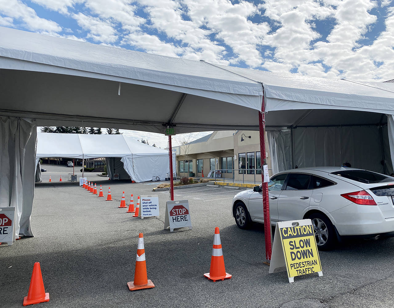 A car pulls into a COVID-19 testing site that is set up outside the Everett Clinic at 4027 Hoyt in Everett on Tuesday. (Sue Misao / The Herald)