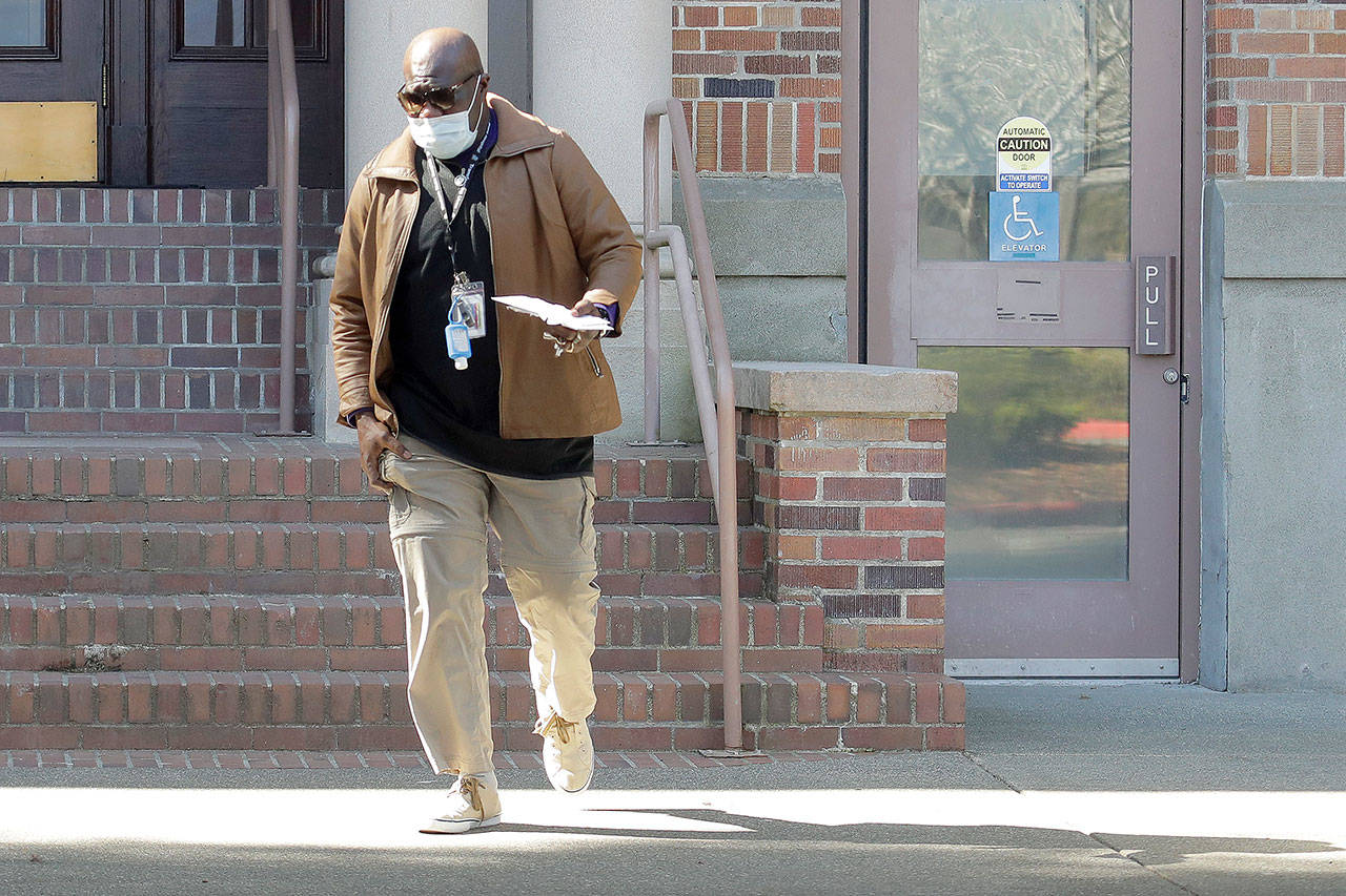 An employee walks near an entrance to Western State Hospital on Thursday in Lakewood. (AP Photo/Ted S. Warren)