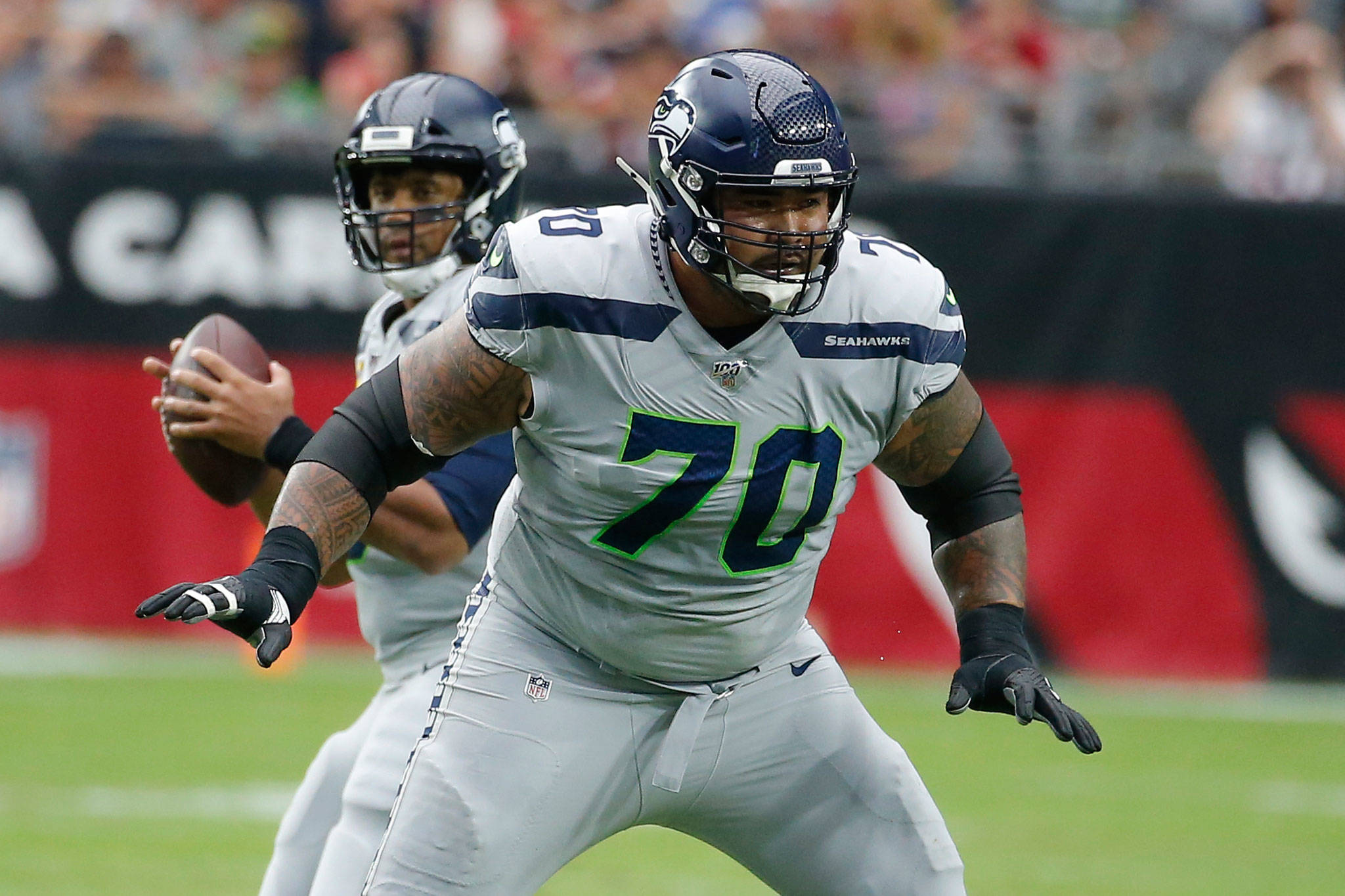 Seahawks offensive guard Mike Iupati (70) block for quarterback Russell Wilson (background) during a game against the Cardinals on Sept. 29, 2019, in Glendale, Ariz. (AP Photo/Rick Scuteri)