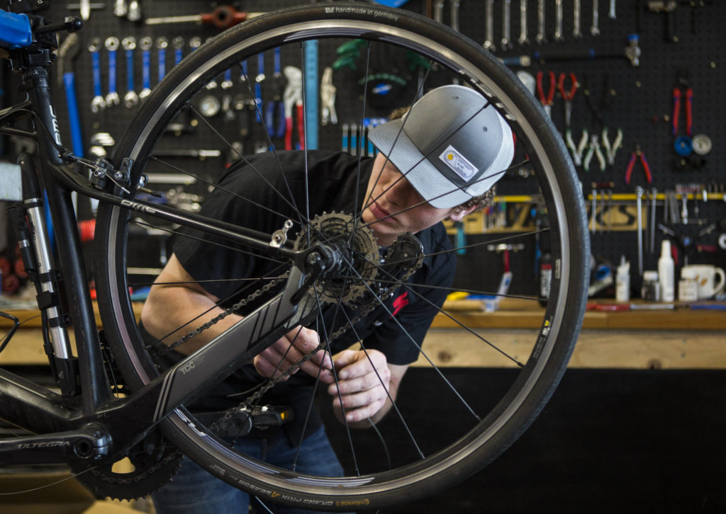 Bicycle Centres of Snohomish mechanic Nolan Sigurdson works on the wheel of a bike on April 18 in Snohomish. The Bicycle Centres have seen record numbers of people over the last few weeks as more people turn to bikes as a means of activity during the COVID-19 pandemic. (Olivia Vanni / The Herald)
