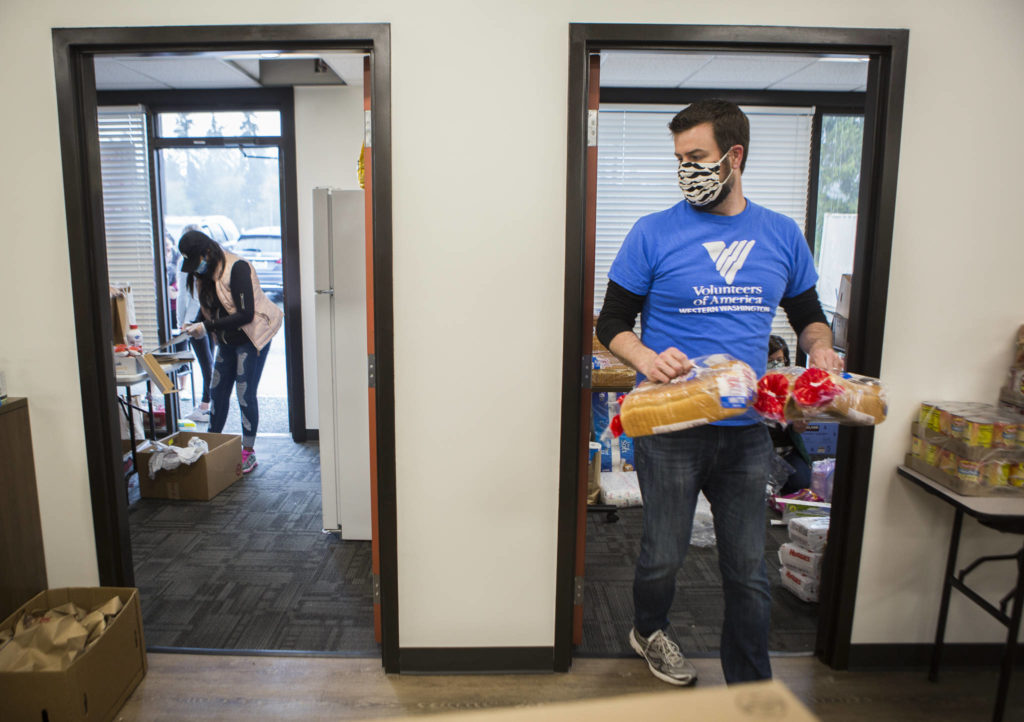 David Jordan helps restock bread April 21 at The Village in Everett. (Olivia Vanni / The Herald)
