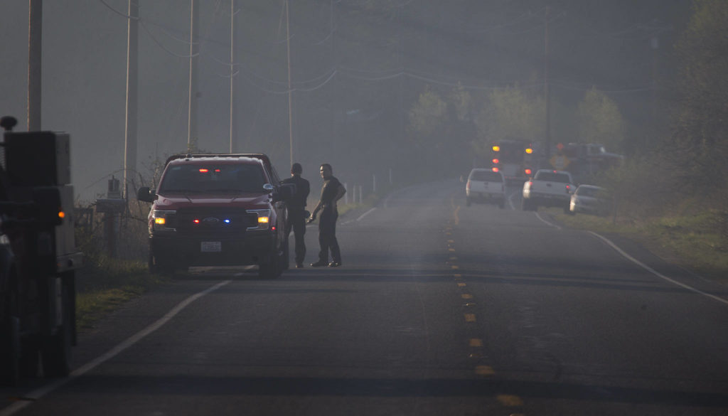 Smoke hovers over Highway 9 as multiple strike teams from Snohomish County fire departments fight a brush fire Wednesday in Bryant. (Andy Bronson / The Herald)
