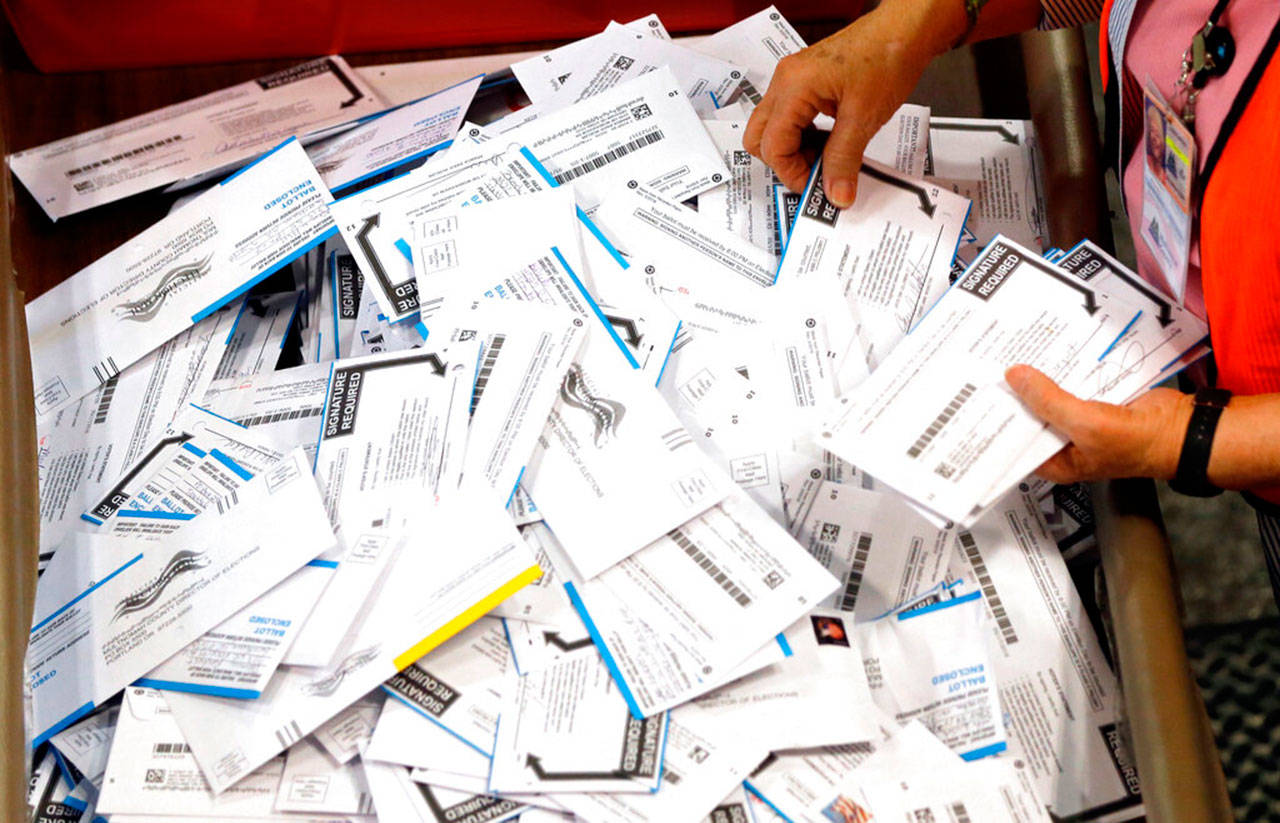 Ballots are prepared for counting at Multnomah County election headquarters in Portland, Ore, in May 2016. The coronavirus has knocked presidential primaries back several weeks as officials worry about voters crowding into polling places. If the disease remains a hazard in November, Democrats say there’s only one solution to preserve the November election, national voting by mail. (Don Ryan / Associated Press file photo)