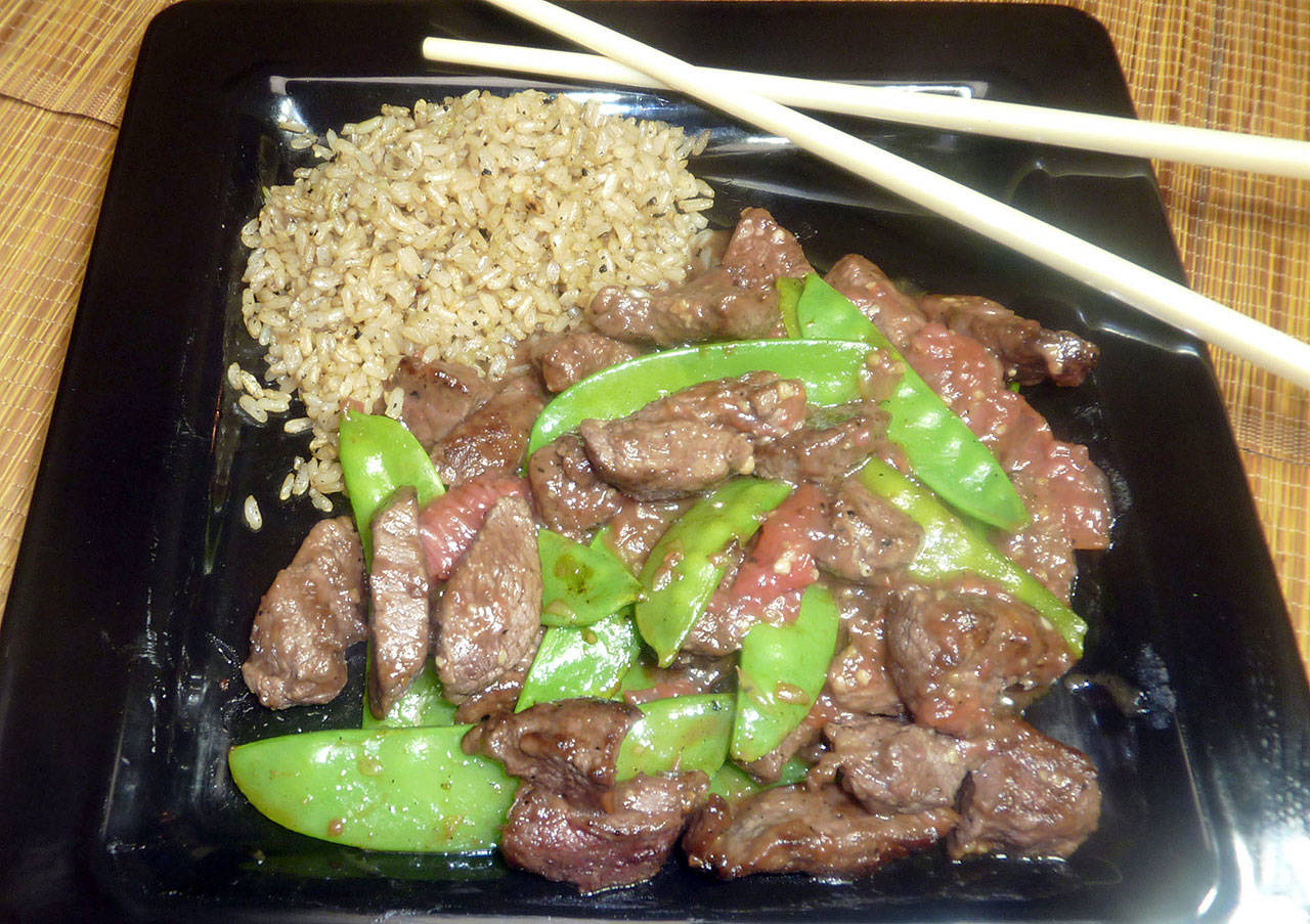 Stir-fried beef, along with crisp brown rice, takes on a unique twist with grapefruit on board. (Linda Gassenheimer)