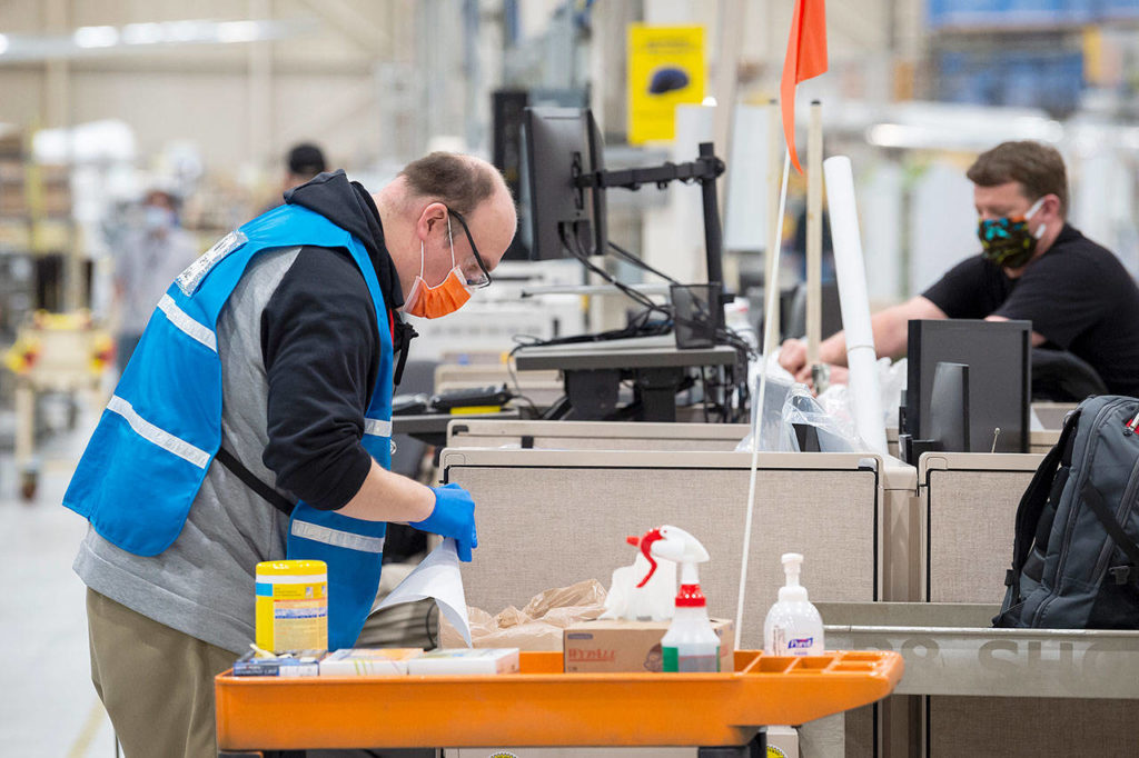 A team cleans shared work stations at the Boeing factory in Renton as defense-related operations restarted last week. (Boeing) 
