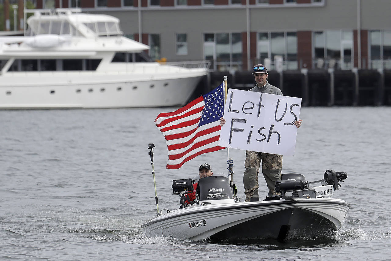 A protester on a boat on Lake Union near Gas Works Park in Seattle on Sunday, during a protest against Washington’s ban on fishing due to stay-at-home orders implemented to prevent the spread of the coronavirus. (AP Photo/Ted S. Warren)