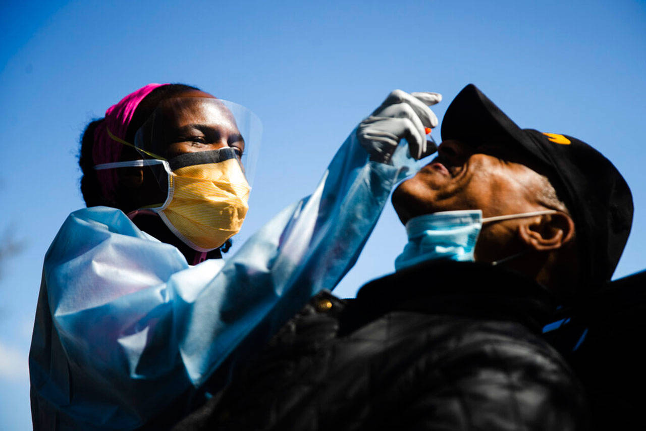 Dr. Ala Stanford administers a COVID-19 swab test on Wade Jeffries in the parking lot of Pinn Memorial Baptist Church in Philadelphia, April 22. Stanford and other doctors formed the Black Doctors COVID-19 Consortium to offer testing and help address heath disparities in the African American community. (Matt Rourke / Associated Press)