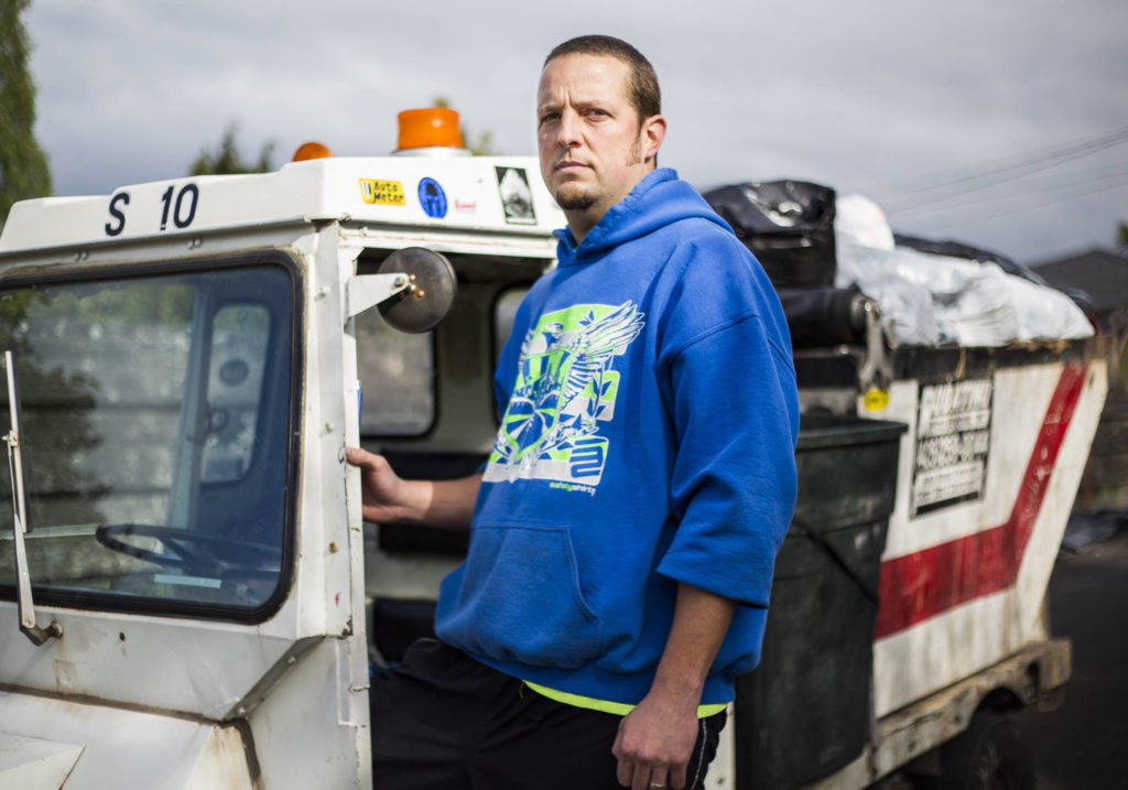 Essential worker Joe Oltman, a Rubatino garbage man for 13 years, at work in Everett. (Olivia Vanni / The Herald)
