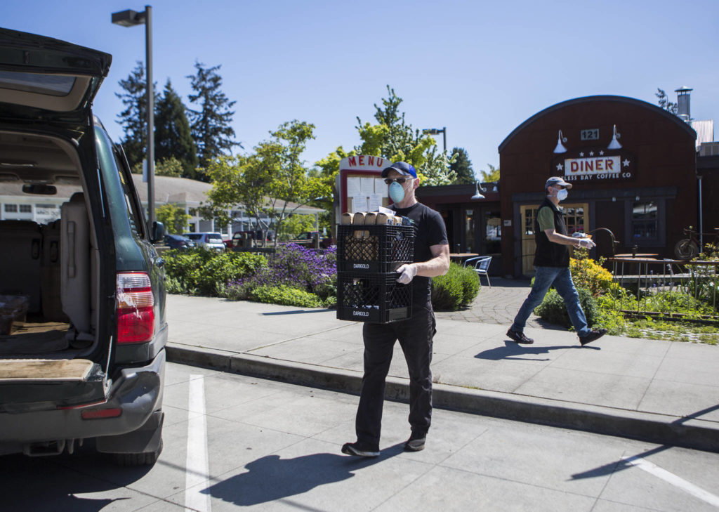 Des Rock, owner of Useless Bay Coffee Company, loads his car with soup for Whidbey Island Nourishes and coffee beans for the Star Store in Langley. (Olivia Vanni / The Herald)

