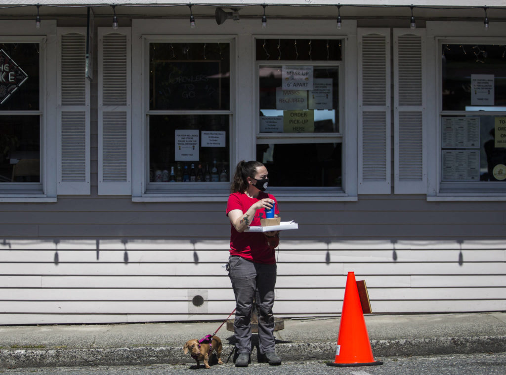 Celean Larmoe and her dog, Sarah, wait to cross First Street in Langley. (Olivia Vanni / The Herald)
