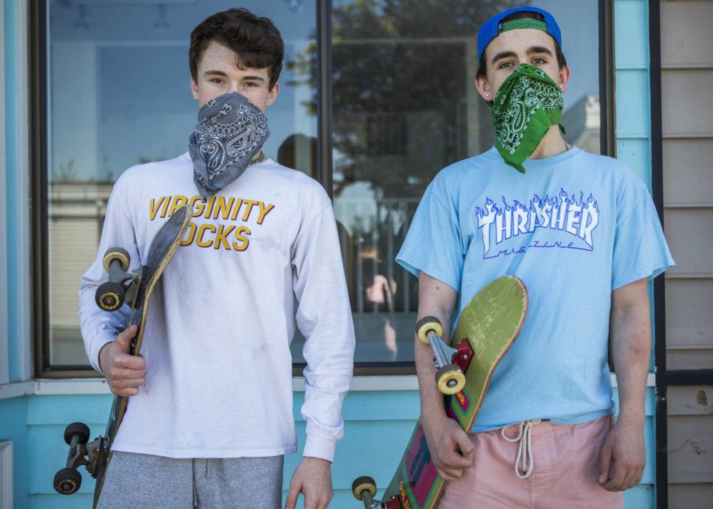 Caleb McArthy, 17 (left), and Hank McCarroll, 15 (right), wear bandana masks while skateboarding in Langley. (Olivia Vanni / The Herald)
