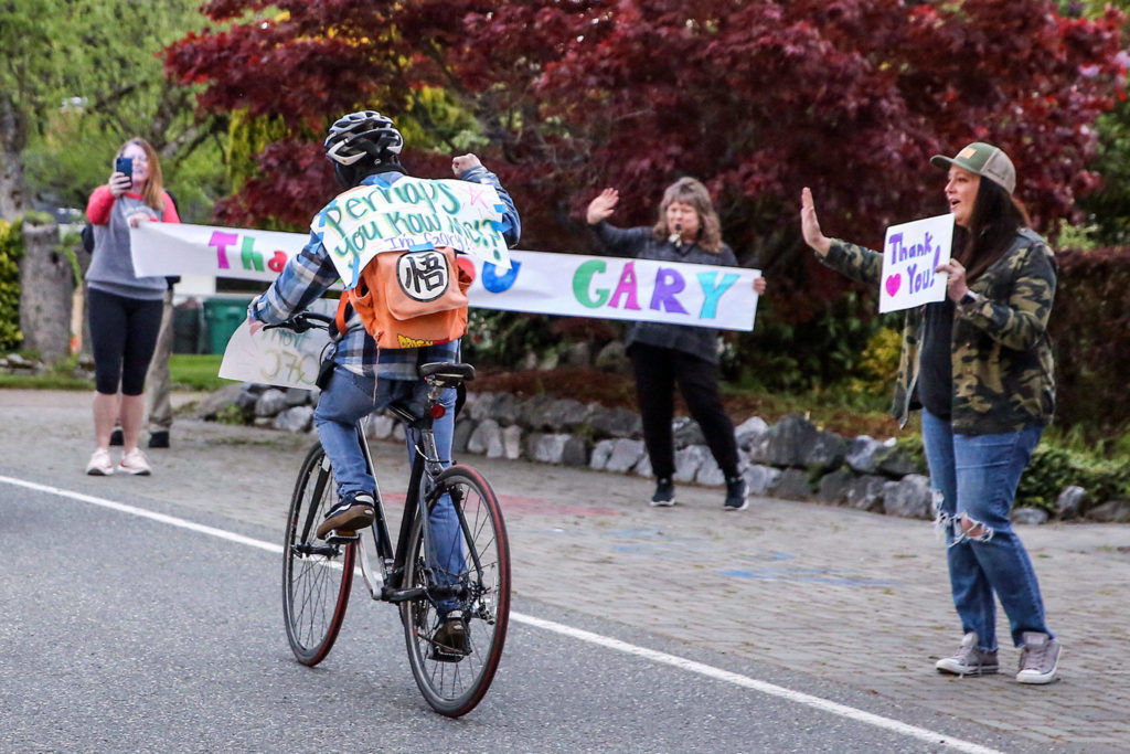 Gary Locke, a QFC worker for 11 years well known for his friendly service, is honored as a frontline hero in a nightly parade on 53rd Avenue West in Mukilteo. (Kevin Clark / The Herald)
