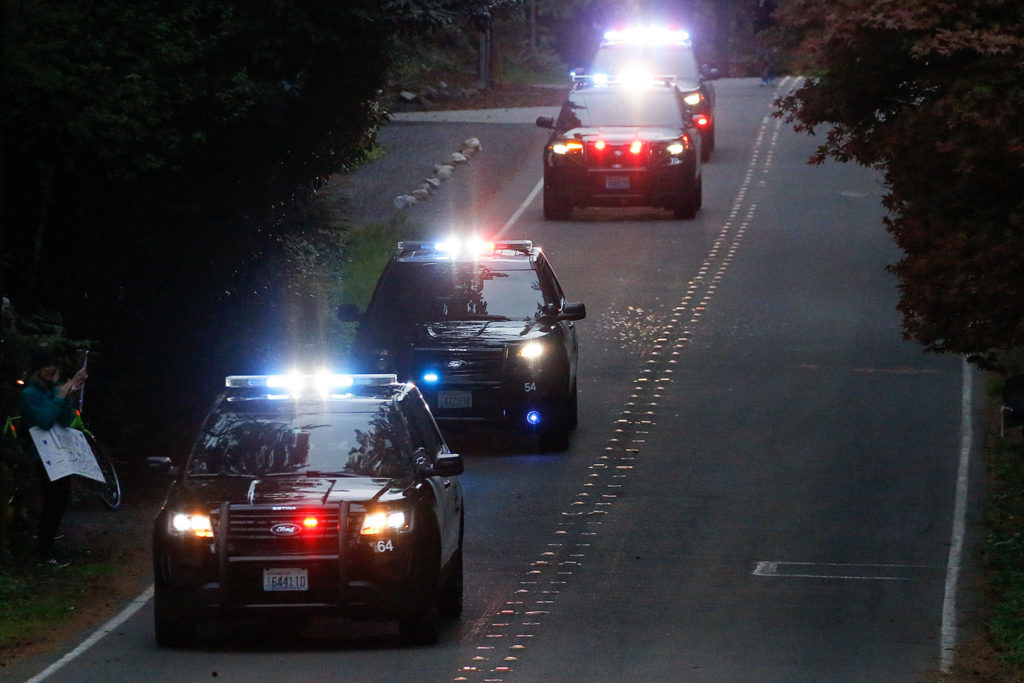 Gary Locke, a QFC worker for 11 years well known for his friendly service, is honored as a frontline hero in a nightly parade on 53rd Avenue West in Mukilteo. (Kevin Clark / The Herald)
