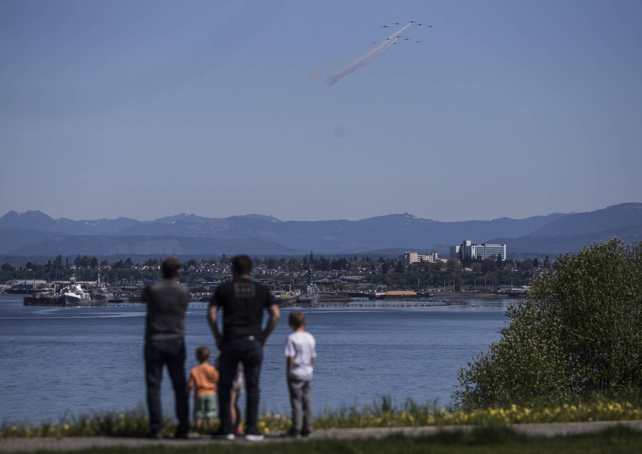 The Huff family watches as the Cascade Warbirds fly over Everett for their V-E Day Remembrance Flight at Harborview Park on Friday in Everett. (Olivia Vanni / The Herald)
