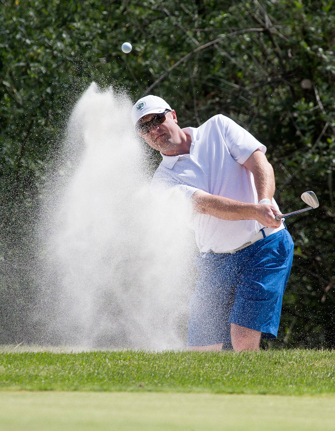 Jacob Rohde hits out of the bunker on the second hole during the final day of the Snohomish County Amateur golf tournament in 2018 at Walter Hall Golf Course in Everett. (Andy Bronson / The Herald)
