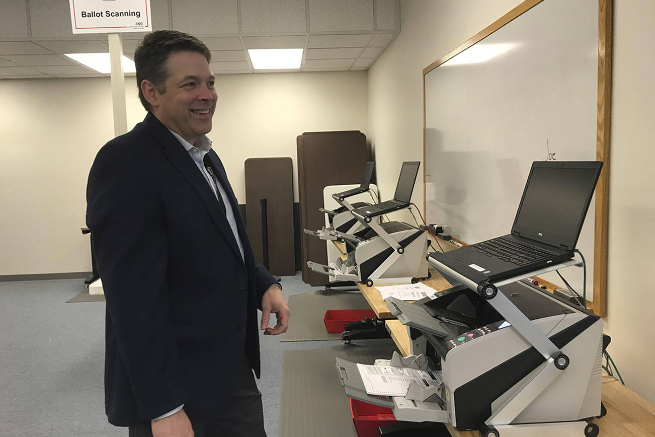 Snohomish County Auditor Garth Fell inspects the testing of ballot-counting equipment prior to the March 10 presidential primary. (Rachel Riley / Herald file photo)